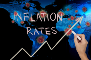 map of world with covid-19 with a person writing inflation rates on a chalkboard