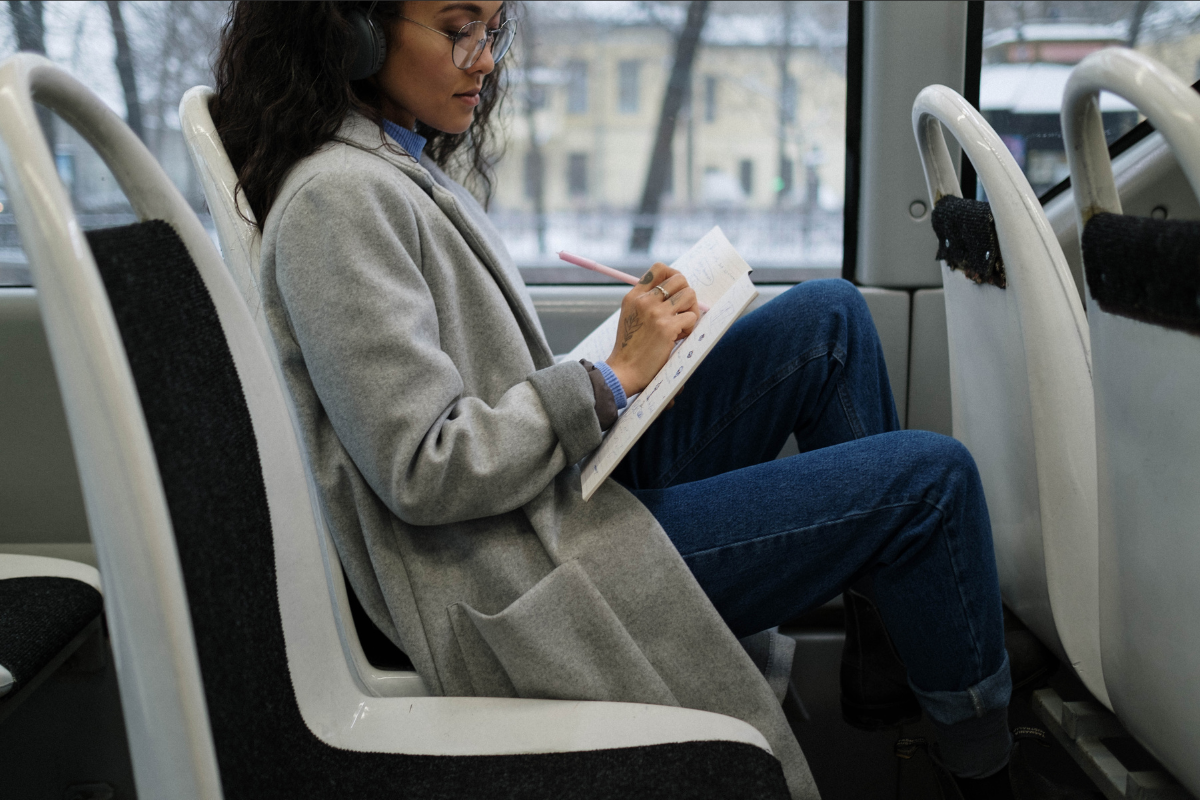 woman writing on public transit