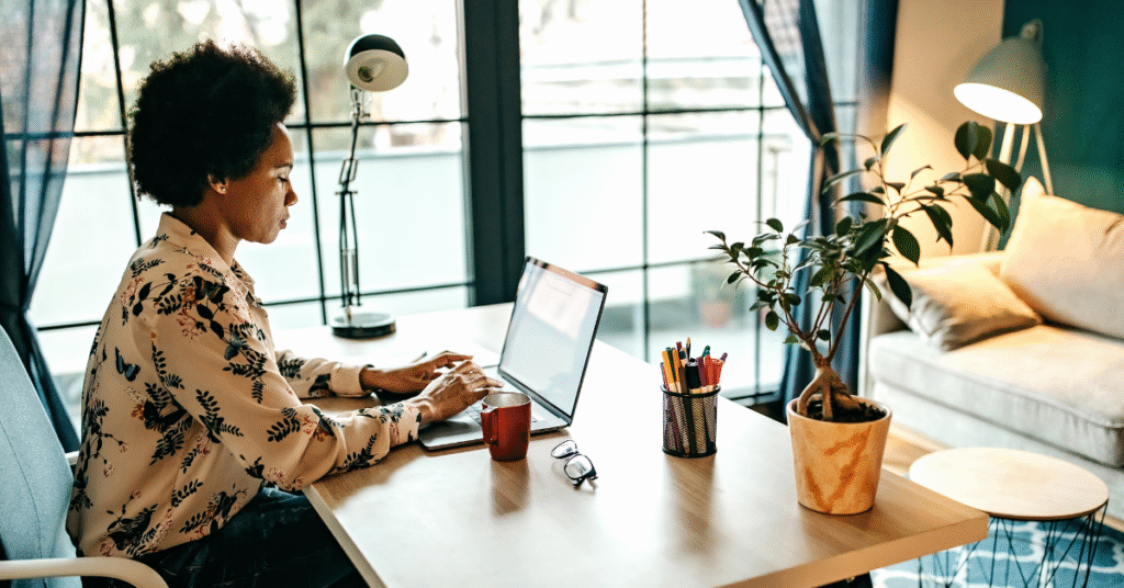 Black woman focused while typing on her laptop in an open, calming office setting