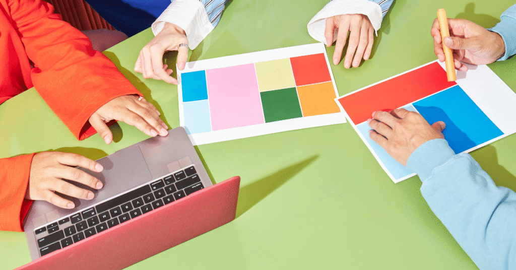 Team reviewing and selecting a brand color palette with printed swatches during a web design strategy session.