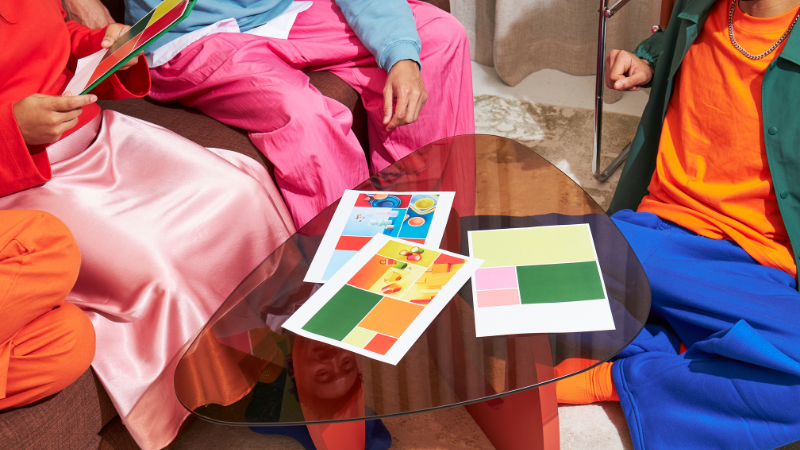 Team reviewing brand color palette samples and layout concepts during creative planning session