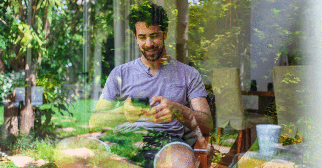 Reflective View into Home Interior and Smiling Man Texting
